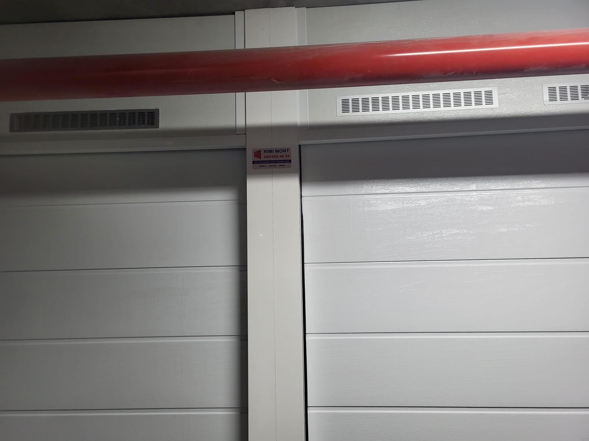 Detalj sekcijskih vrata u podzemnoj garaži s Rimi Mont naljepnicom